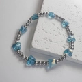 Dettaglio delle perle d'argento lucido e ciondoli a farfalla in vetro blu del bracciale - Farfalla Blu / Acciaio-Blu