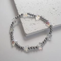 Dettaglio di perline a farfalla in vetro bohémien e sfere metalliche su bracciale intrecciato - Farfalla Trasparente / Acciaio-Trasparente