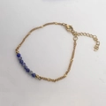 Detail einer vergoldeten Kette mit blauen Natursteinperlen und Sternanhängern - Weißblau