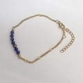 Detail eines Goldkettenarmbands mit blauen Lapislazuli-Perlen und verstellbarem Verschluss - Lapislazuli