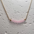 Macro-opname van een fijne gouden ketting met kleine doorschijnende roze kwartskralen - Rozenkwarts