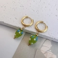 Detailopname van gouden oorringen met groene glazen hangers en stippatroon versiering - Groen