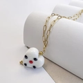 Detail of white glazed heart pendant with red and black dots on gold stainless steel chain - White