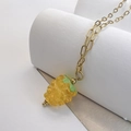 Detailed close-up of a yellow glass berry pendant on a gold paperclip chain necklace - Yellow