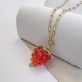 Detailed close-up of a glass raspberry pendant on a gold-plated paperclip chain necklace - Red
