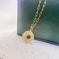 Detailed view of golden sunburst pendant with black stone on a paperclip chain - Gold-Black Agate