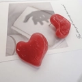Detalle de pendientes de corazón rojo con textura de mármol y pernos de acero - Rojo
