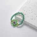 Dettaglio dell'anello di perline con ciondolo floreale in vetro Millefiori e sfere dorate - Verde