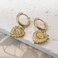 Detalle macro de pendientes de aro dorados con colgantes de corazón mal de ojo - Juego de Pendientes de Aro de Corazón / Dorado
