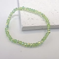 Detail of light green faceted crystal bracelet with rainbow AB coating on white background - Green
