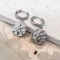 Detailed view of silver hoop earrings with textured starfish relief coin pendant - Starfish Earrings / Steel