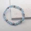 Macro detail of 6mm light blue faceted glass beads and polished steel beads on stretch bracelet - Blue-Steel