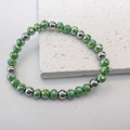 Macro detail of 6mm light green faceted beads and silver steel beads on elastic bracelet - Green-Steel