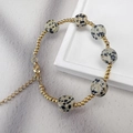 Dettaglio di perline in oro 18K e pietre di agata su un bracciale con chiusura - Diaspro dalmata