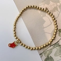 Detalle de pulsera de cuentas doradas elásticas con un colgante de calcetín navideño - Calcetín de Navidad Rojo