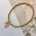 Detailed close-up of golden beaded stretch bracelet with a festive gingerbread man charm - Gingerbread Man (E Snowman)