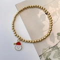 Macro detail of golden 4mm stainless steel beaded bracelet with Santa Claus charm - Santa Claus