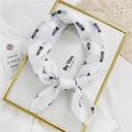 White chiffon scarf with black 'Pretty Girl' characters displayed on a gold frame - White Pretty Girl
