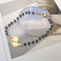Detail of bohemian black bead bracelet featuring gold baby footprint charms and lobster clasp - Baby Footprint Pendant