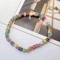 Nahaufnahme bunter Millefiori-Glasperlen mit Blumenmuster auf einem Perlenarmband - Bunt