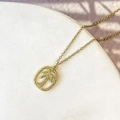 Détail d'un pendentif palmier doré avec texture martelée sur une fine chaîne dorée - Style Cocotier Encadré (DN273)