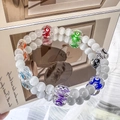 Close-up of beaded evil eye bracelet with colorful glass beads on a reflective surface - Evil Eye with White Round Beads (LY401) / Multicolor And White