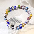 Dettaglio di braccialetti in vetro millefiori colorato con vivaci perline a sorriso - 6mm
