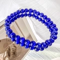 Detail shot of deep blue cat eye stone beads on a double-layer bracelet with mirror reflection - 6mm / Sapphire Blue