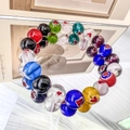 Detail of colorful round glass beads with embedded red hearts on an elastic bracelet - Round-10mm