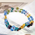 Detailed view of colorful glass beads featuring red heart motifs on a water ripple surface - Flat Bead - 6mm