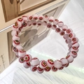 Macro shot of glass beaded bracelet with colorful millefiori evil eye flower patterns - 6mm White Red Flower