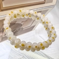 Detailed view of yellow daisy pattern beads on a translucent handmade glass bracelet - 6mm White Yellow Flower