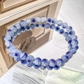 Detail of blue millefiori glass bead bracelet with daisy flower pattern and matte texture - 6mm White Blue Flower