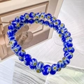 Detailed view of handmade blue glass bead bracelet with white daisy flower patterns - 6mm Dark Blue