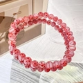 Detail of pink glass beaded bracelet with red daisy flower patterns and elastic band - 6mm Pink