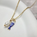 Detail of gold necklace featuring baroque pearl and blue striped fish enamel pendant - Blue