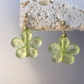 Dettaglio di orecchino a fiore in cristallo verde chiaro con perno in metallo dorato - Verde