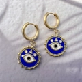 Detailed view of gold stainless steel earrings with blue enamel evil eye charms - Style B Round