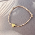 Pink and gold woven cord bracelet with a polished golden heart pendant and leaf shadow - Gold - Heart