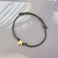 Detail of adjustable black and gold cord bracelet with a polished star pendant - Gold - Star
