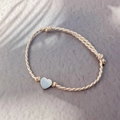 Detail of adjustable woven heart charm bracelet with pink cord and polished metal beads - Steel-Heart