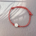 Detail of red and gold woven cord bracelet with polished round metal charm and adjustable knots - Steel Color - Round