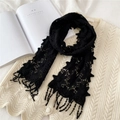 Eleganter schwarzer Spitzen-Blumenschal mit Quasten auf einer weißen Strickjacke - Schwarz