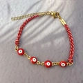 Detailed view of handmade woven evil eye bracelet with red beads and 18K gold plated clasp - Red