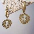 Detailed close-up of golden monstera leaf hoop earrings on a white stone background - Hollow Monstera Leaf Style (DE179-P280)