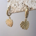 Detail der goldenen Monstera-Ohrringe auf weißem Stein mit matter Textur und poliertem Reif - Dicke Creolen Monstera Blatt Stil (DE479-P105)