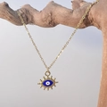 Nahaufnahme der goldenen Evil Eye Halskette mit Anhänger auf einer Holzstruktur - Klassisches Auge (眼睛)