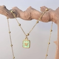 Detail showing a vintage-style butterfly square pendant on a beaded gold-plated chain - Green