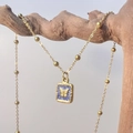 Detail of square gold butterfly pendant necklace with blue enamel on wooden branch - Navy Blue