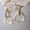 Detailed macro of gold geometric earrings with pearl-white irregular triangle pendants - Gold with Pearl White